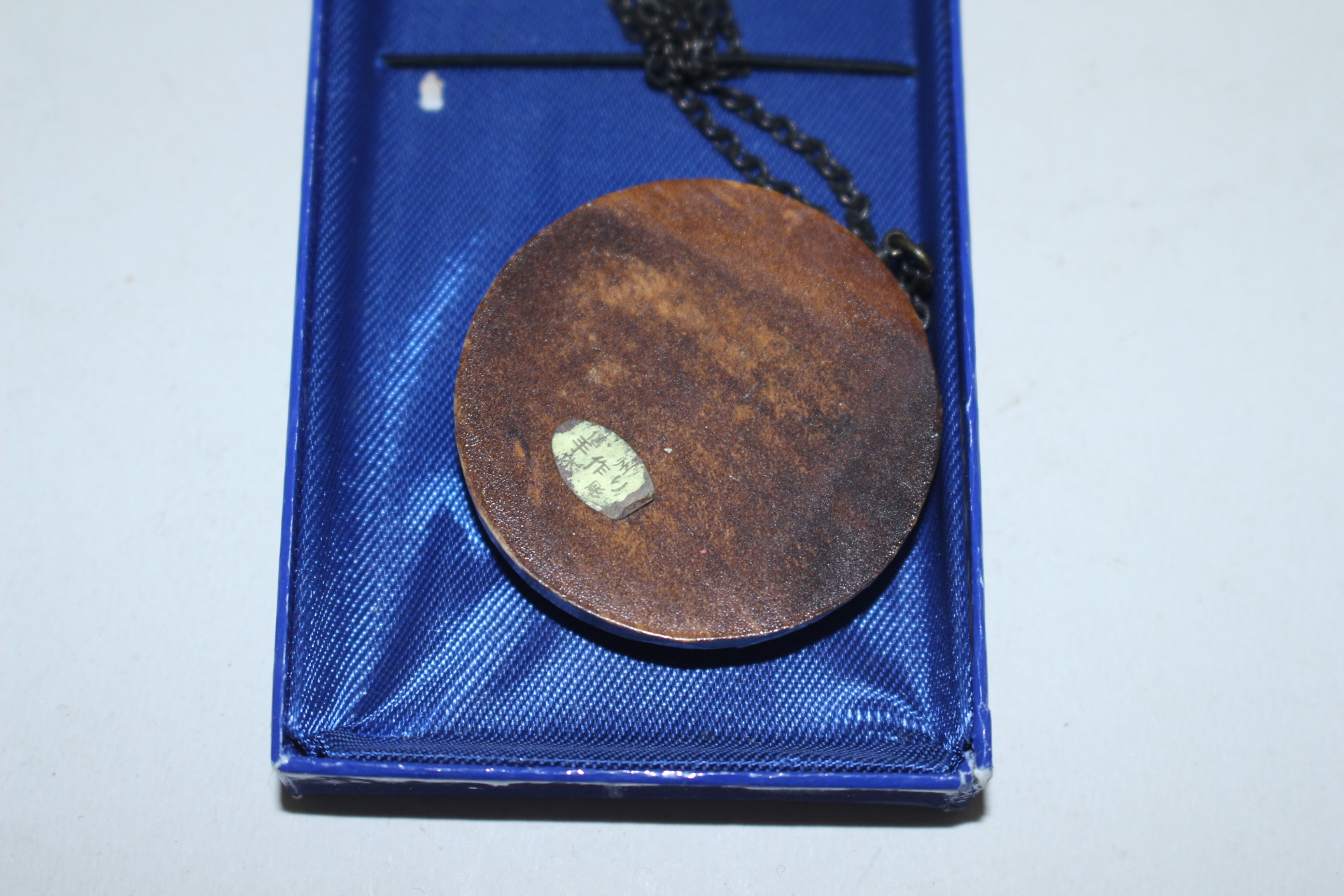 나무에 화문이 조각된 목걸이