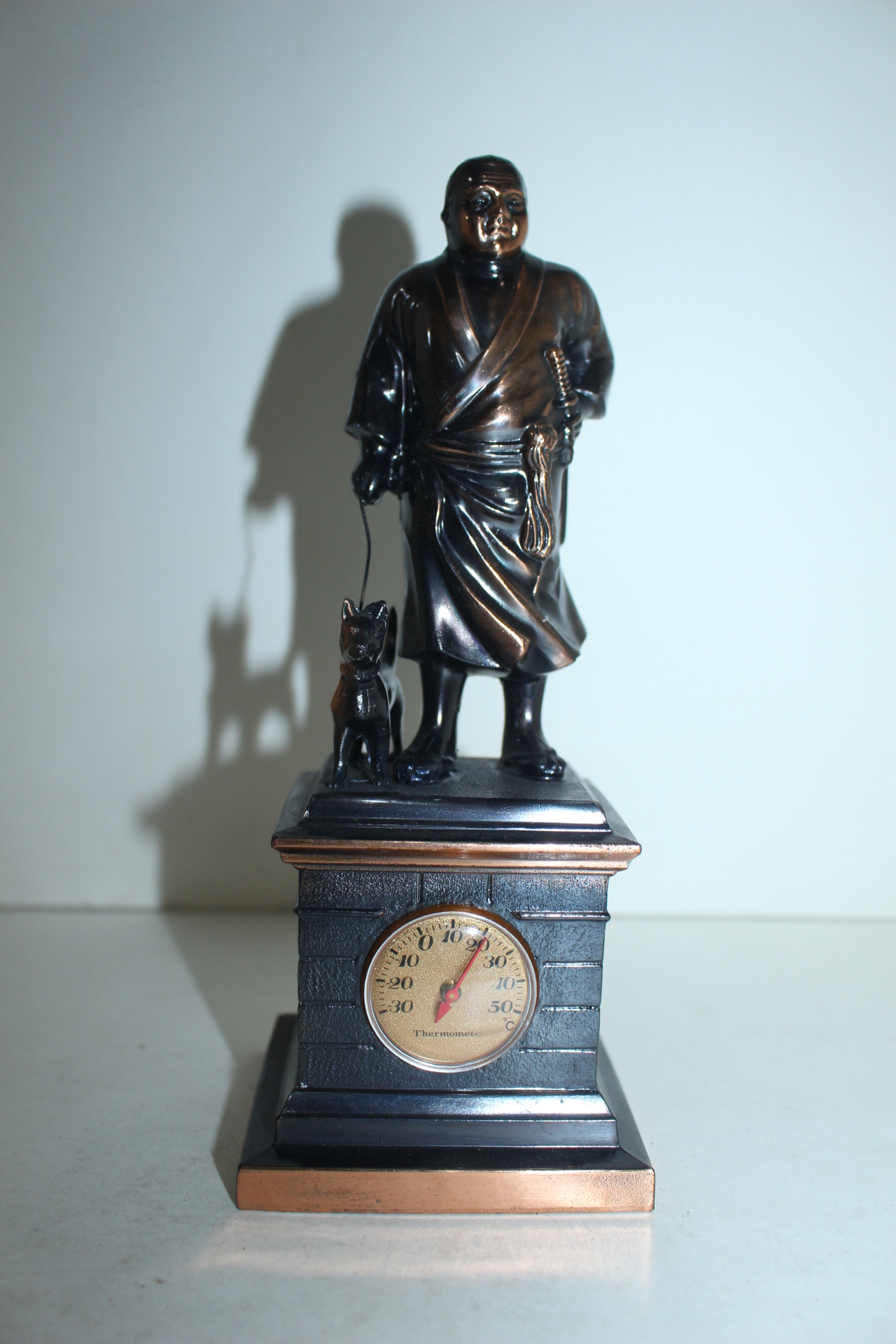 묵직한 금속재질로된 온도계가있는 인물동상 조각상