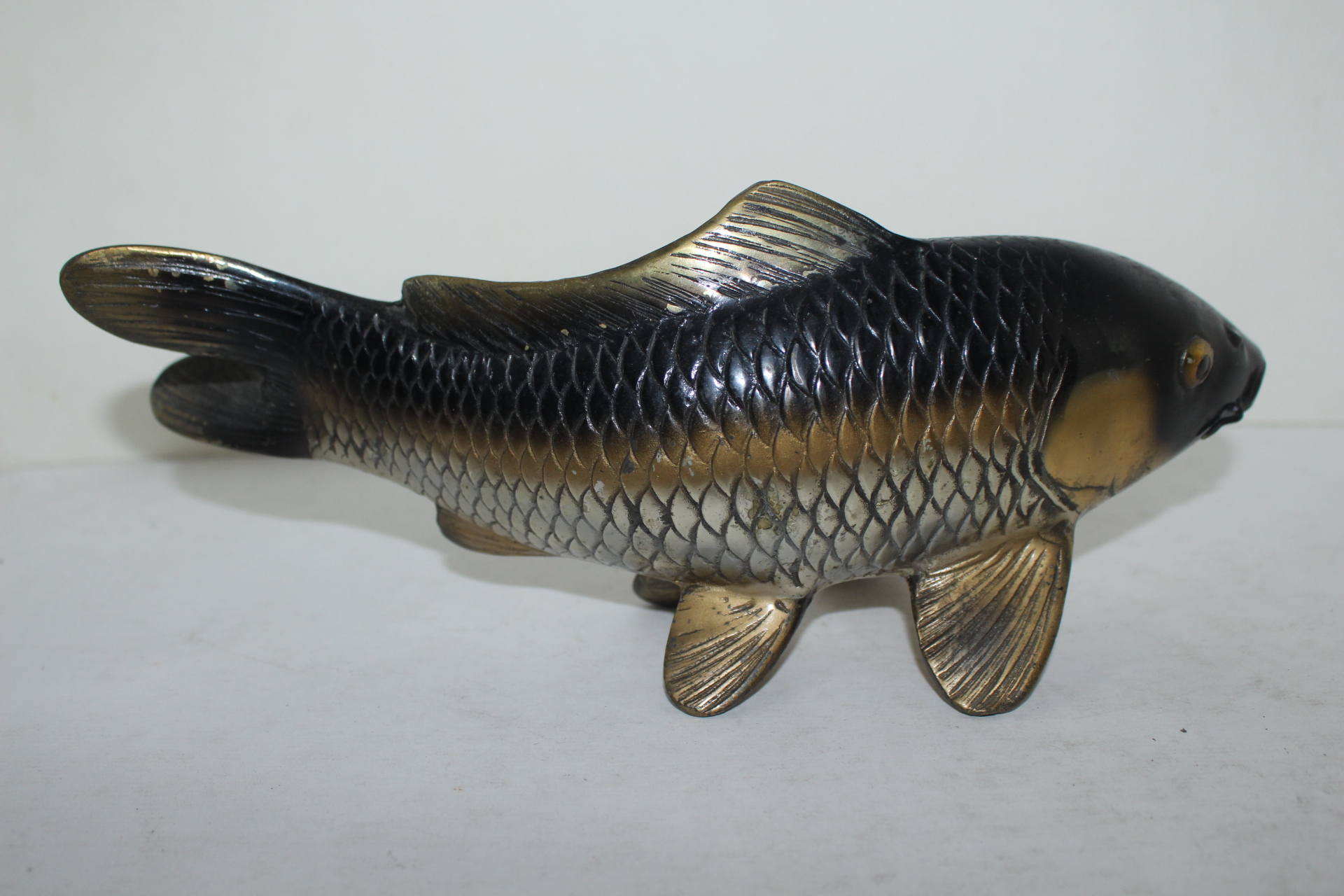 묵직한 청동으로된 작가의 작품인 물고기 조각상